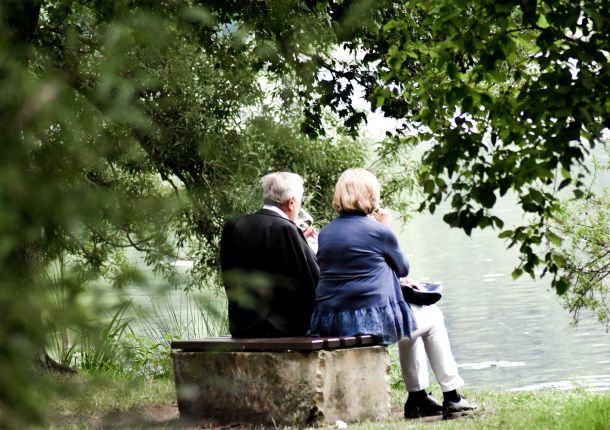 Älteres Ehepaar auf einer Bank am See