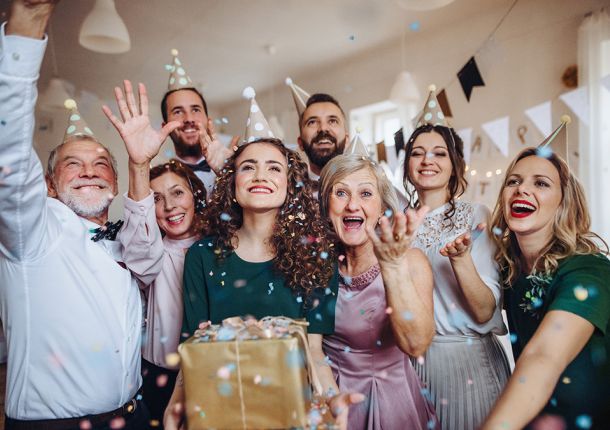 Ein Porträt einer Mehrgenerationenfamilie mit Geschenken, die auf einer Geburtstagsfeier im Haus stehen.