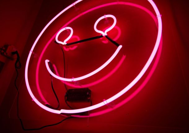Leuchtende LED-Lampe in Pink, an einer Wand angebracht.