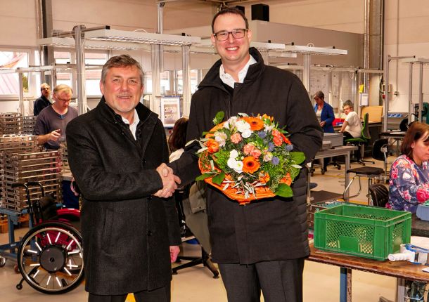 Axel Gloeckle mit den Backnanger Werkstätten, die ihm einen Blumenstrauß überreichen und sich freudig für die Spende bedanken.